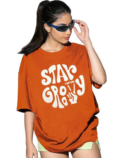 Stay Groovy Typography Printed Drop Shoulder Oversized T-Shirt for Women (Orange) – Trendy Half Sleeve Tee with Classic Round Neck, Soft & Breathable Cotton Blend Fabric for Comfort & Durability. Perfect for a Casual, Comfy, and Stylish Look!